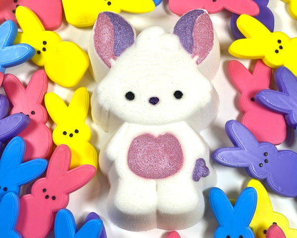 White bunny with a pink heart surrounded by colorful bunny-shaped toy